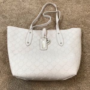 Cream colored Bebe tote with small black bag.